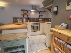 Een koelkast, kookgerei, borden en bestek