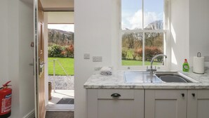 Una cocina con ventana, un lavabo y un extintor.