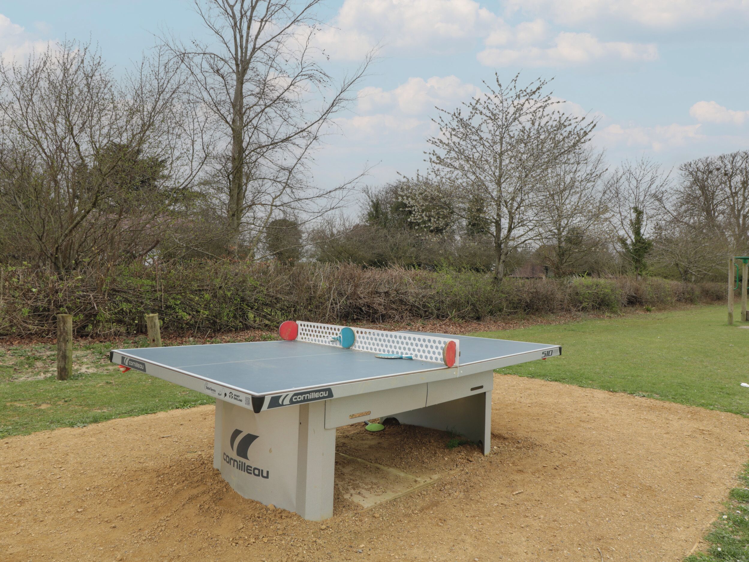 Mesa de ping-pong con red en un entorno exterior.
