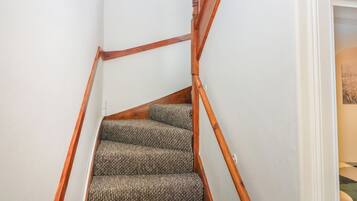 Una scala con corrimano in legno e gradini rivestiti di moquette.