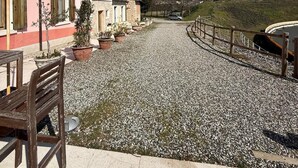 Um edifício rosa com entrada por um caminho de cascalho e cerca de madeira.
