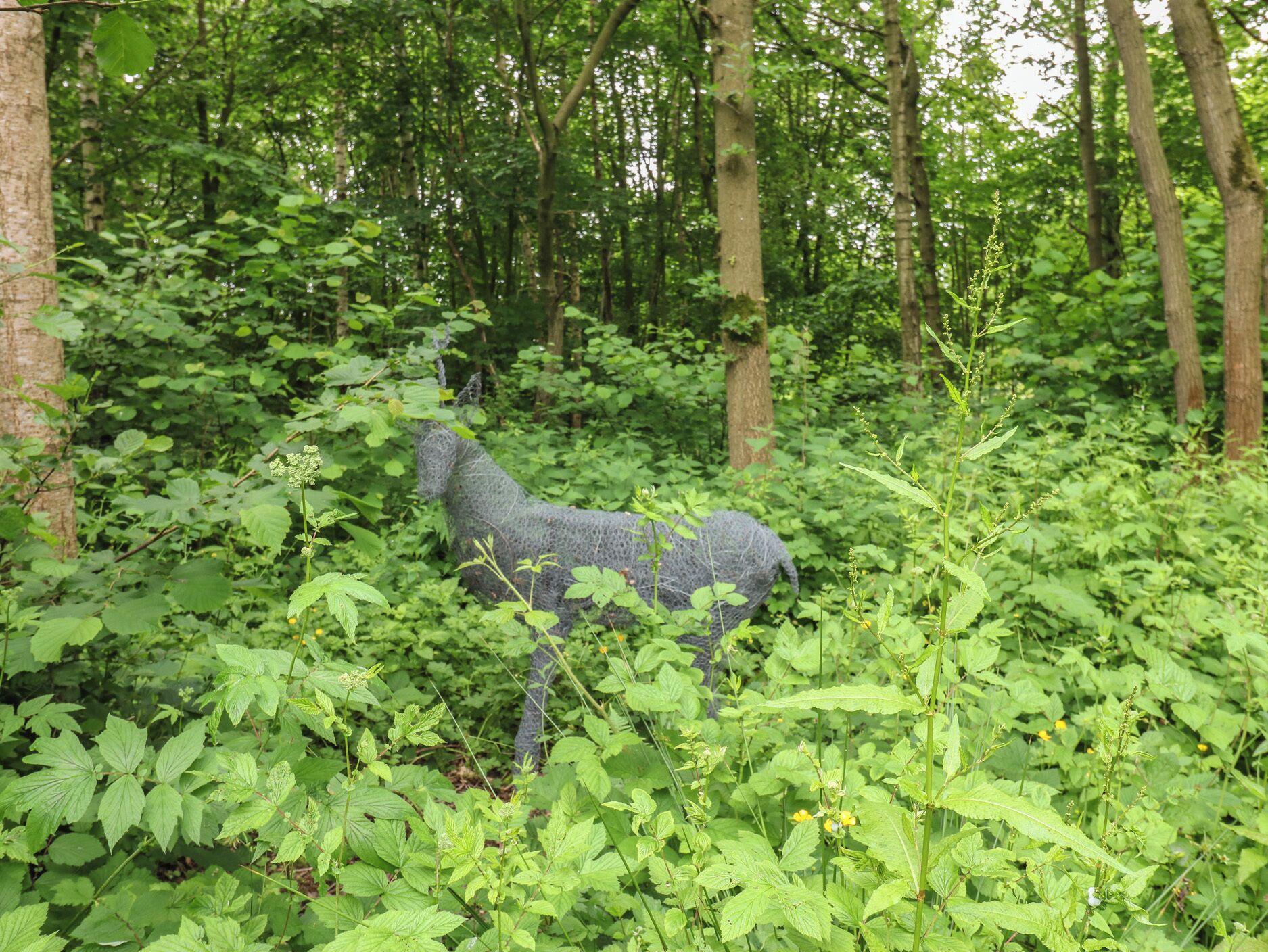 Una scultura di uncinetto in una foresta.