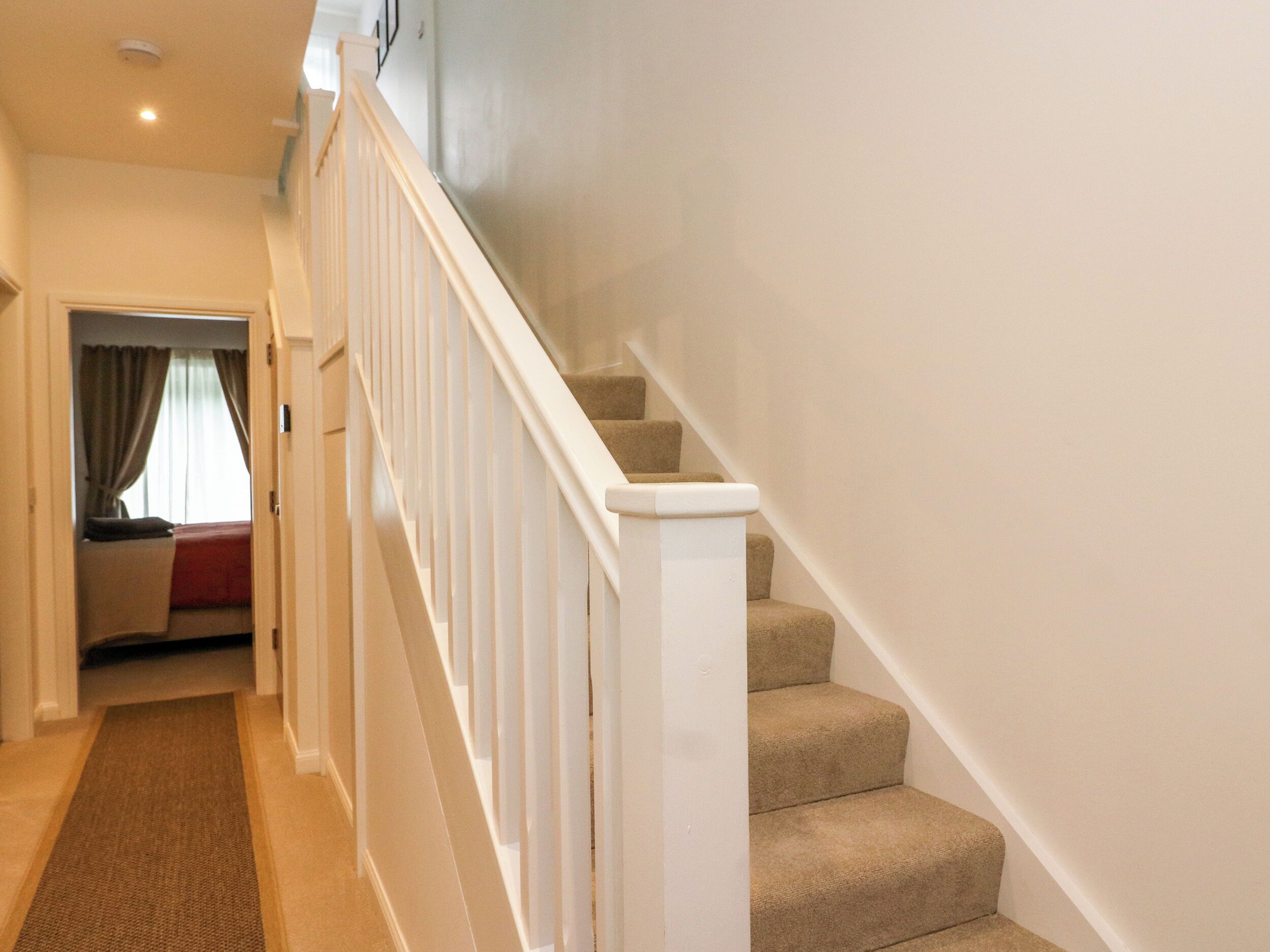 A staircase with white railings leading to a landing.