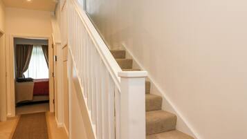 A staircase with white railings leading to a landing.