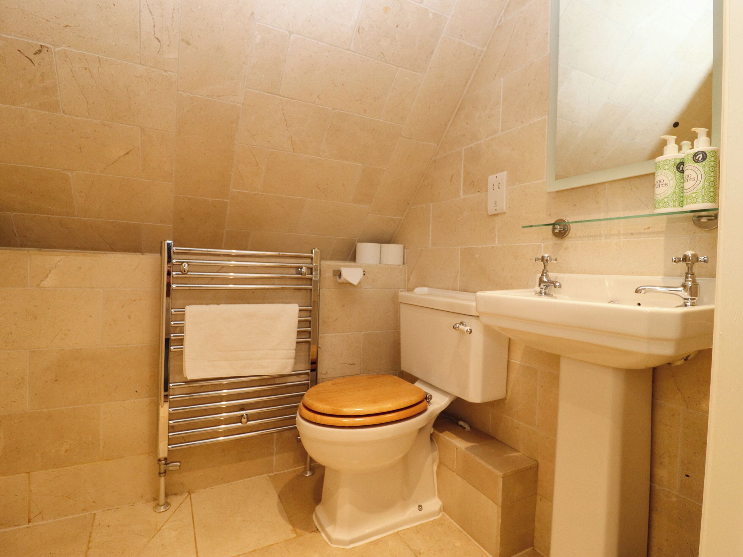 A small bathroom with a toilet, a sink, and a towel rack.