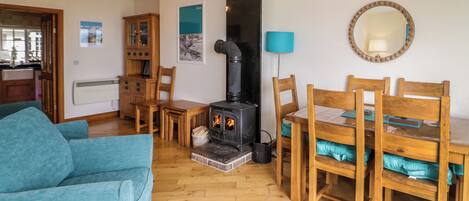 Una sala de estar acogedora con chimenea, muebles de madera y un comedor.