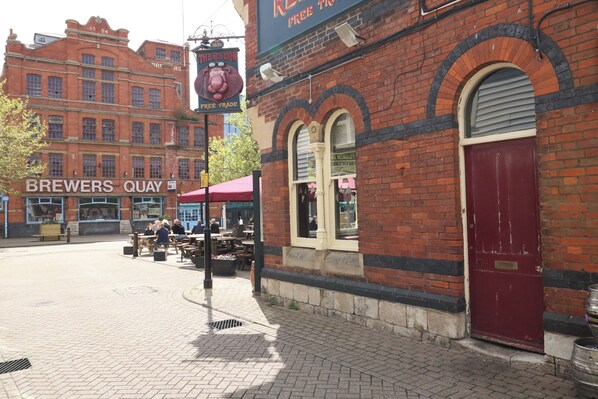 A street with a red brick building labeled 'BREWERS QUAY' and a sign for 'THE RED LION FREE TRADE.' - Mackerel Cottage (Weymouth)