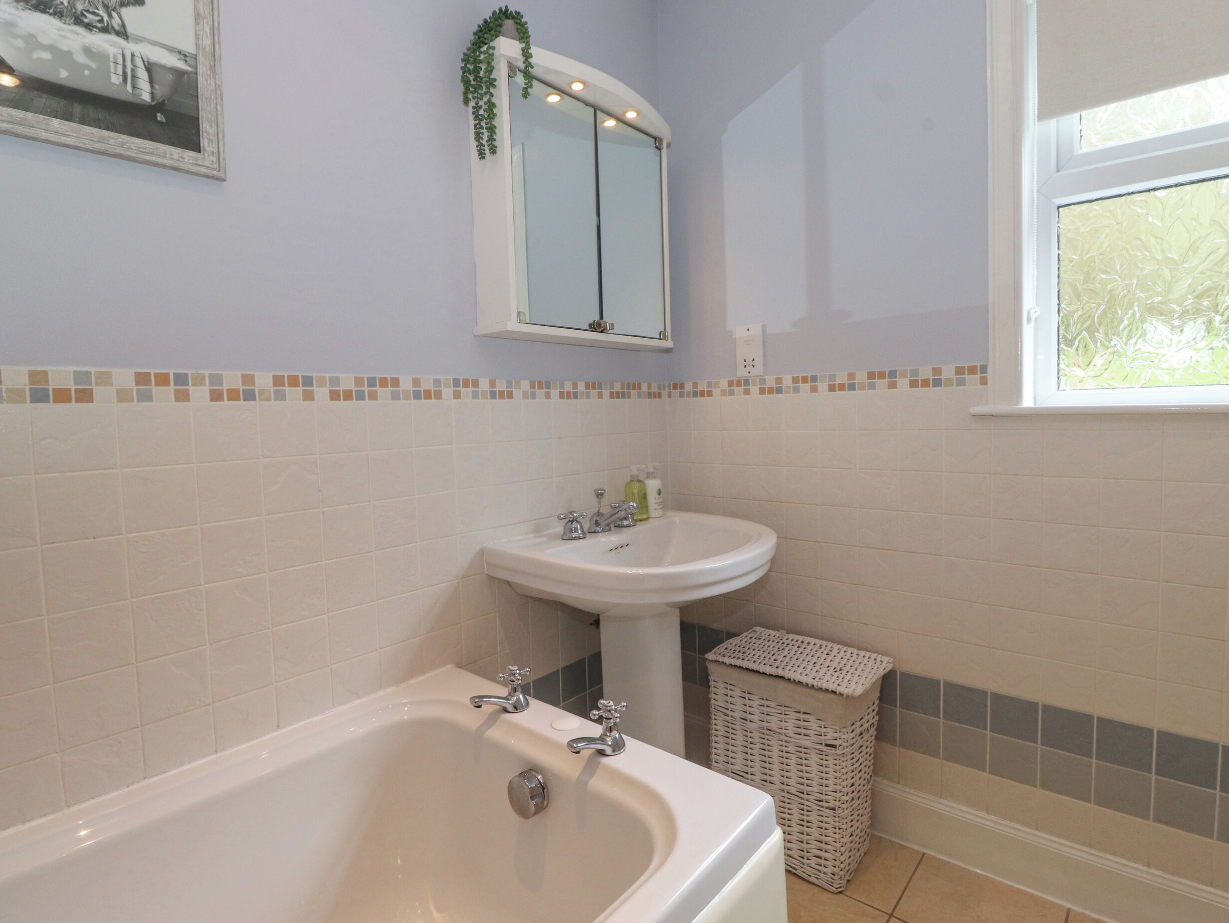 A bathroom with a bathtub, a sink, and a mirror.
