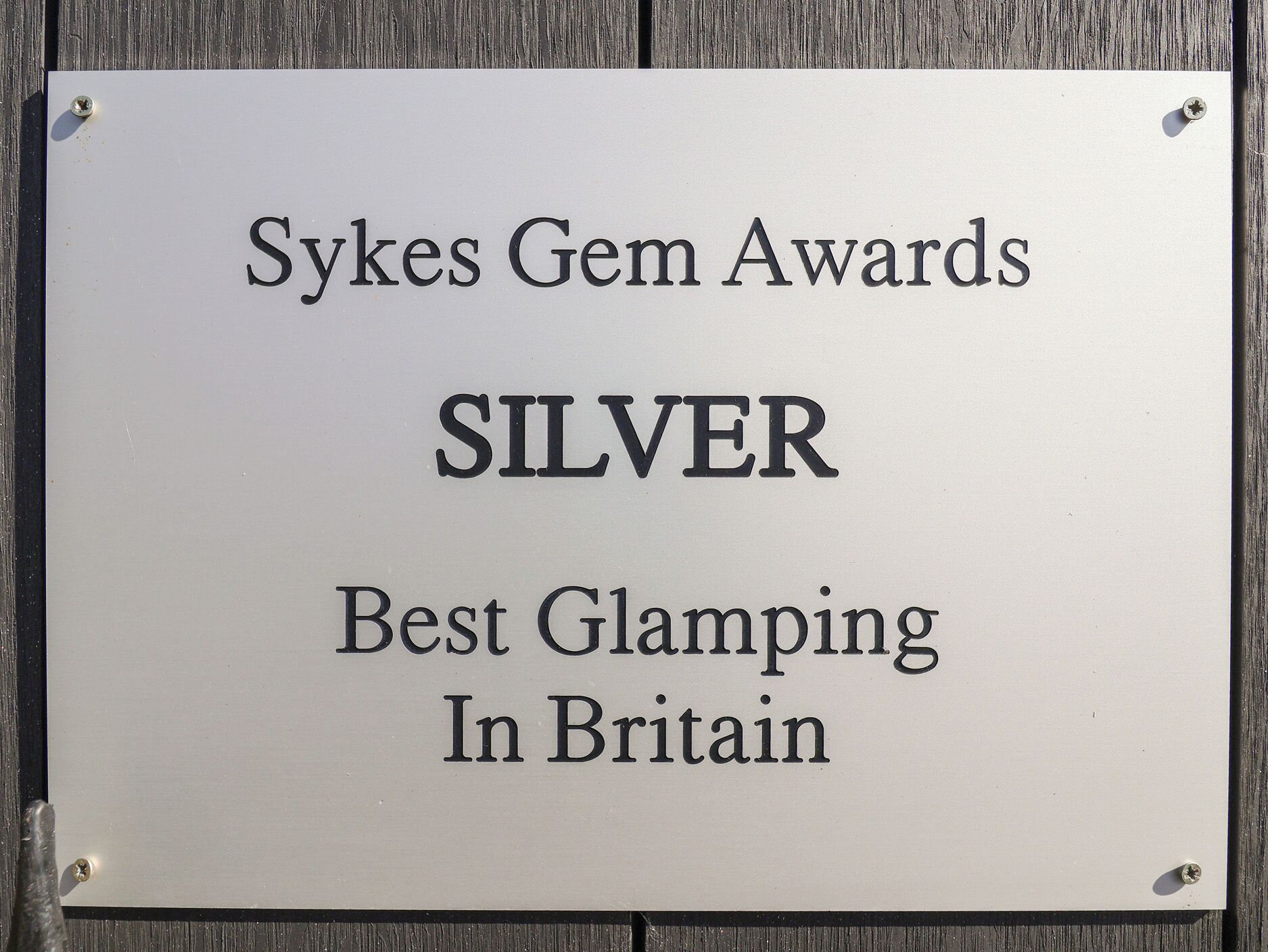 Schild für die Sykes Gem Awards, das eine silberne Auszeichnung für das beste Glamping in Großbritannien anzeigt.