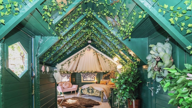 A cozy attic bedroom with a sloped ceiling, a bed, a chair, and a large window. - Applejacks Orchard (Holywell)