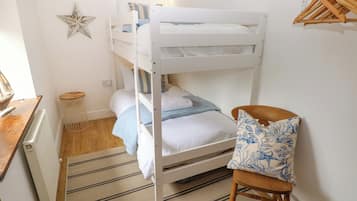 Habitación con literas, una silla de madera y una decoración de estrellas en la pared.