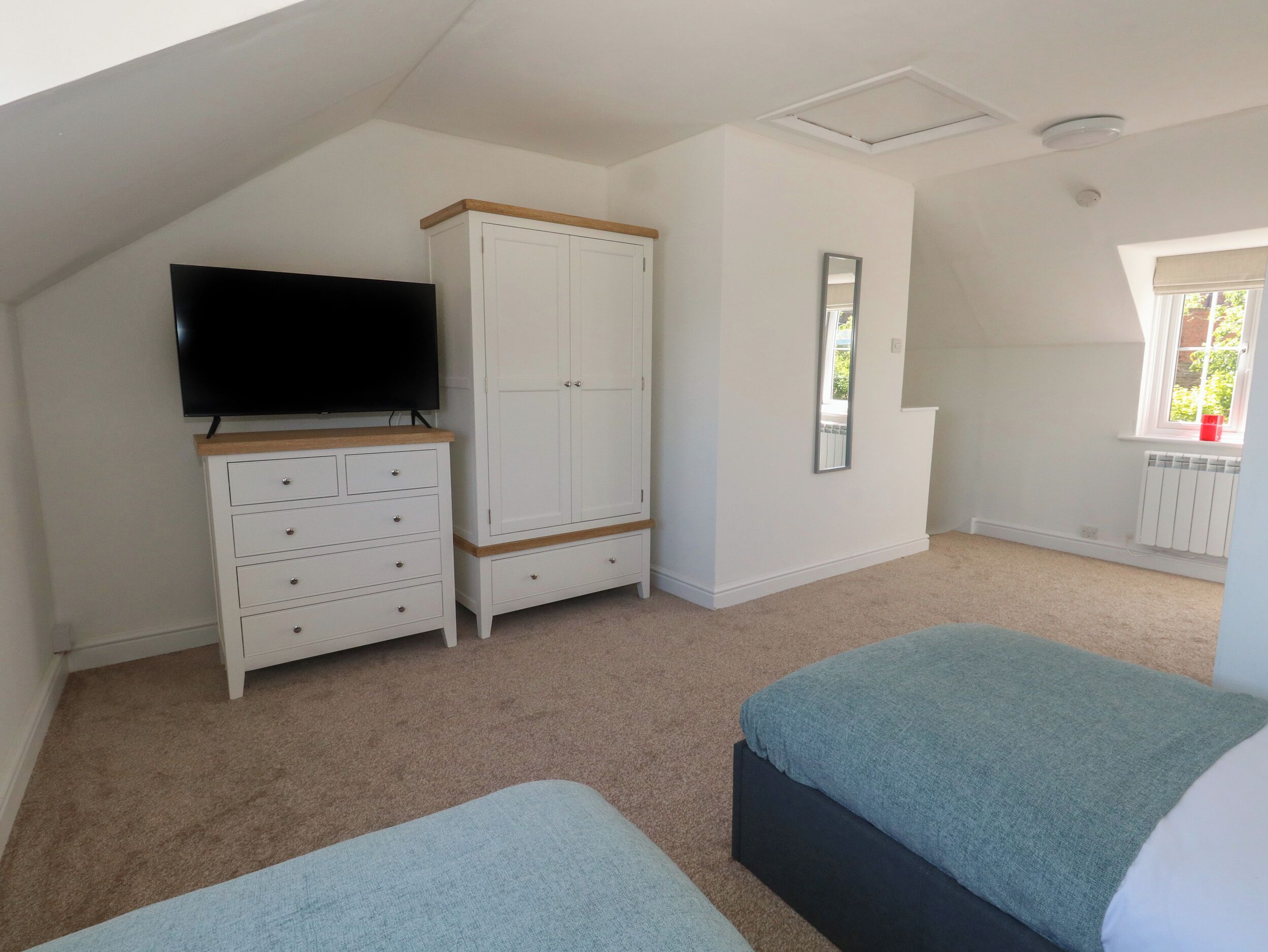 Ein Schlafzimmer mit Fernseher, Kleiderschrank und zwei Betten.