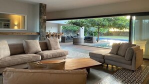 Una sala moderna con un ventanal grande, un juego de sofás y una mesa de centro.