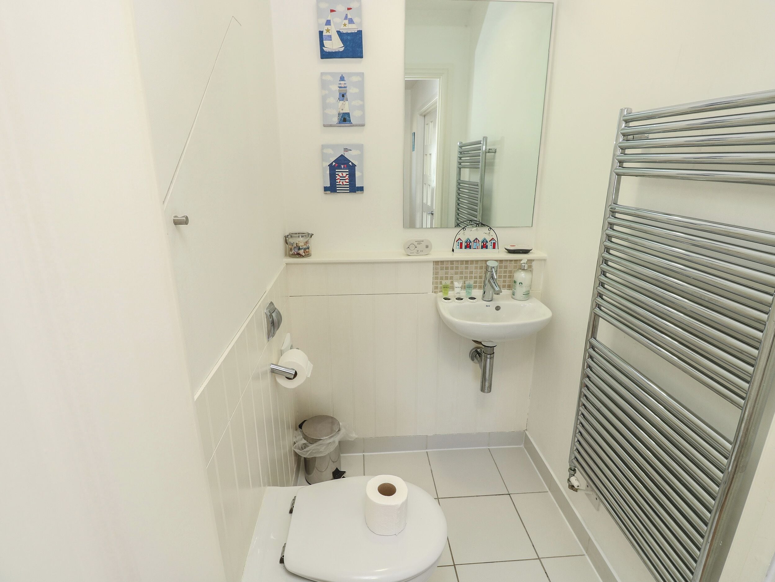 A small bathroom with a toilet, sink, and towel rack.