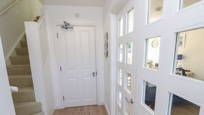 A hallway with a white door, a staircase, and a door with multiple windows. - Whitfield P5 (Yarmouth)