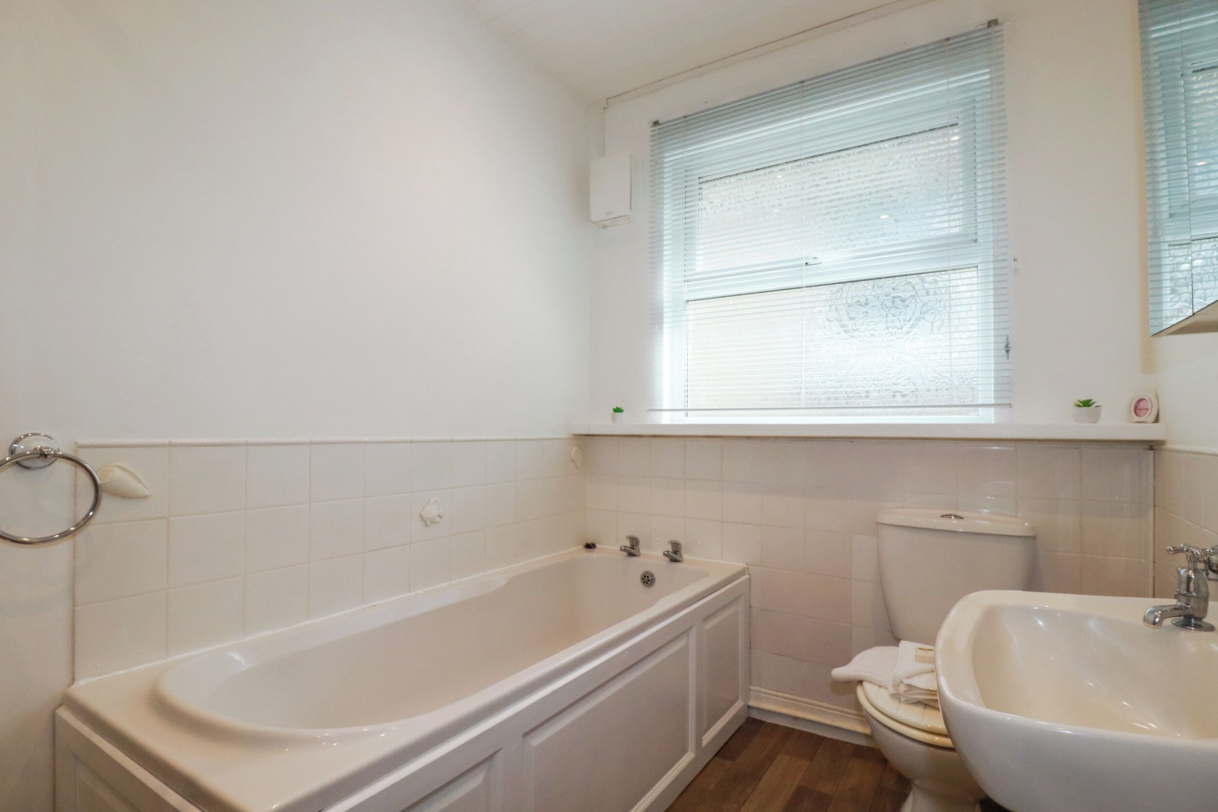 A bathroom with a bathtub, toilet, and sink.