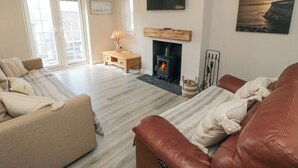 A living room with a fireplace, a sofa, a TV, and a painting on the wall.
