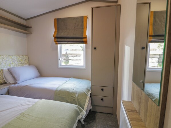 A bedroom with two beds, a wardrobe, a window with a view, and a mirror. - 11A Mansion View (Helensburgh)