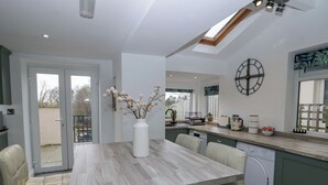 Een moderne keuken met een centraal eiland, een inbouwvaatwasser en een groot raam.