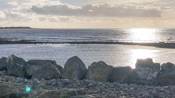A rocky shoreline with a calm sea and a clear sky. - Dove Cottage (Leek)