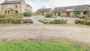 A rural village with stone houses, a gravel driveway, and a stone wall. - Dove Cottage (Leek)