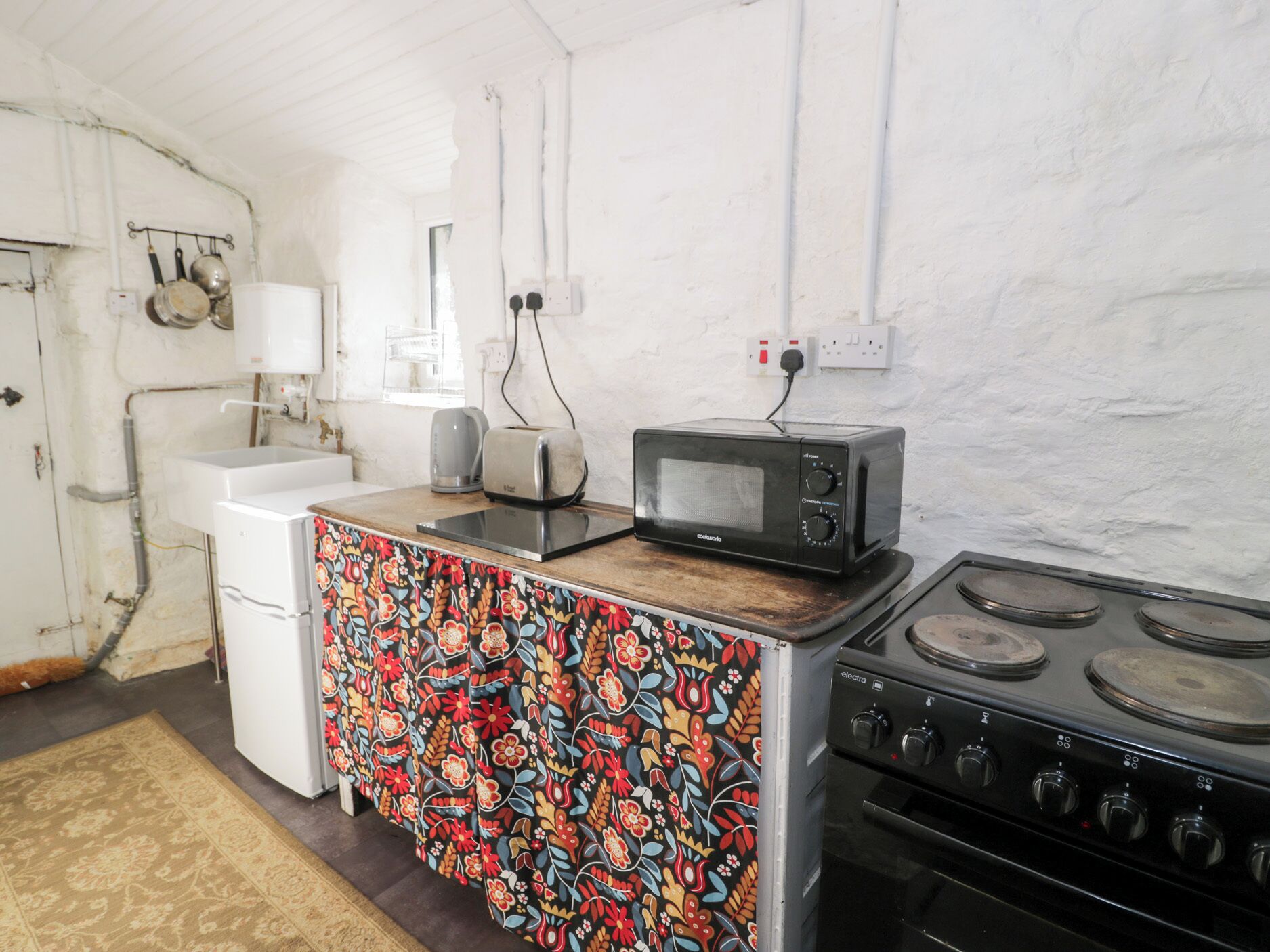 A compact kitchen with a microwave, toaster, and stove.