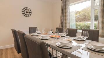 A dining area with a table set for six, including plates, bowls, and wine glasses.