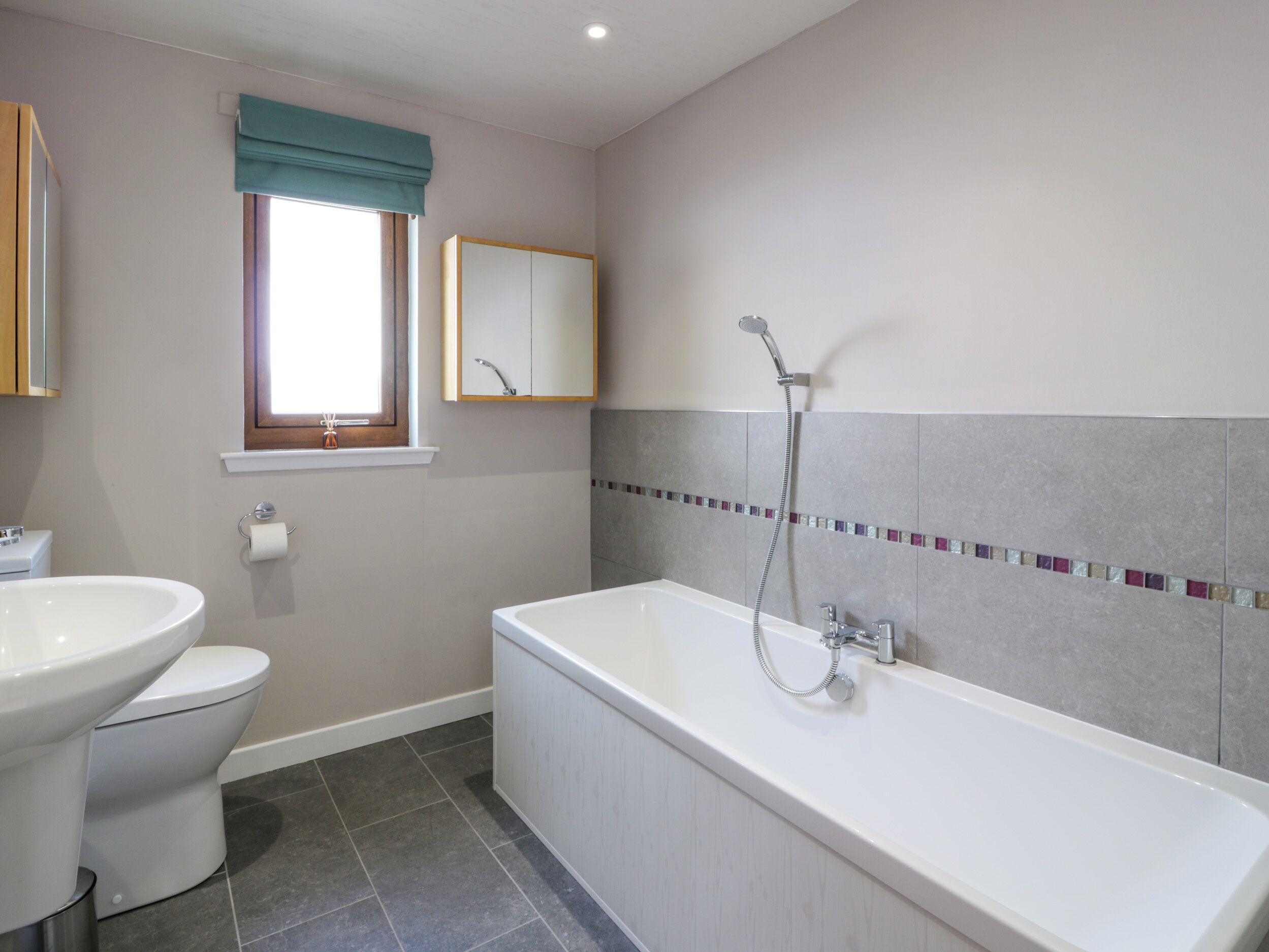 A bathroom with a toilet, sink, and bathtub.