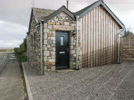 Un edificio de piedra con una puerta negra y una sección de madera.