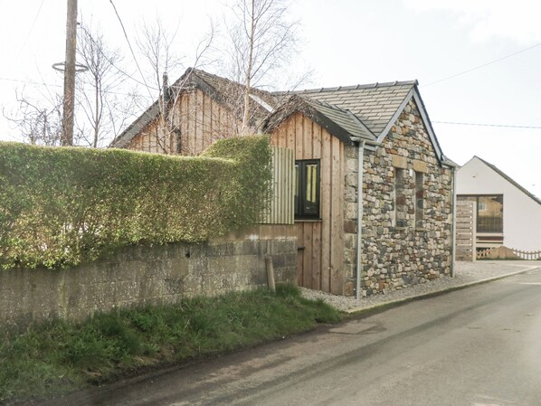 A stone building with a wooden door and a small window. - Driftwood Studio (Ulverston)