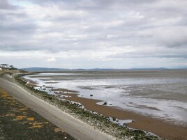 Una carretera costera con una playa arenosa y un litoral rocoso.