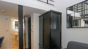 Una sala de estar moderna con un sofá gris, un aparador negro y un espejo grande en la pared.