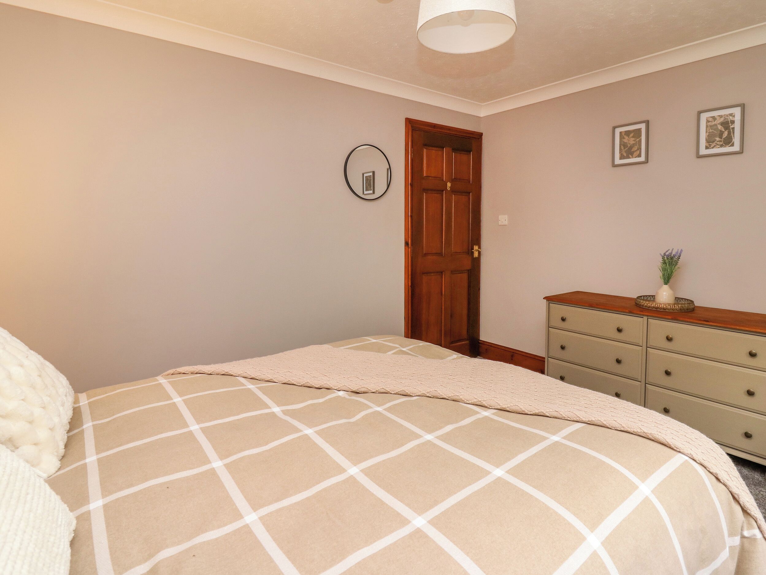 Un dormitorio con cama, cómoda y puerta.
