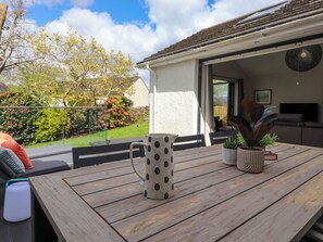 A wooden deck with a white mug, potted plants, and a glass. - Yonder Lea (Windermere)