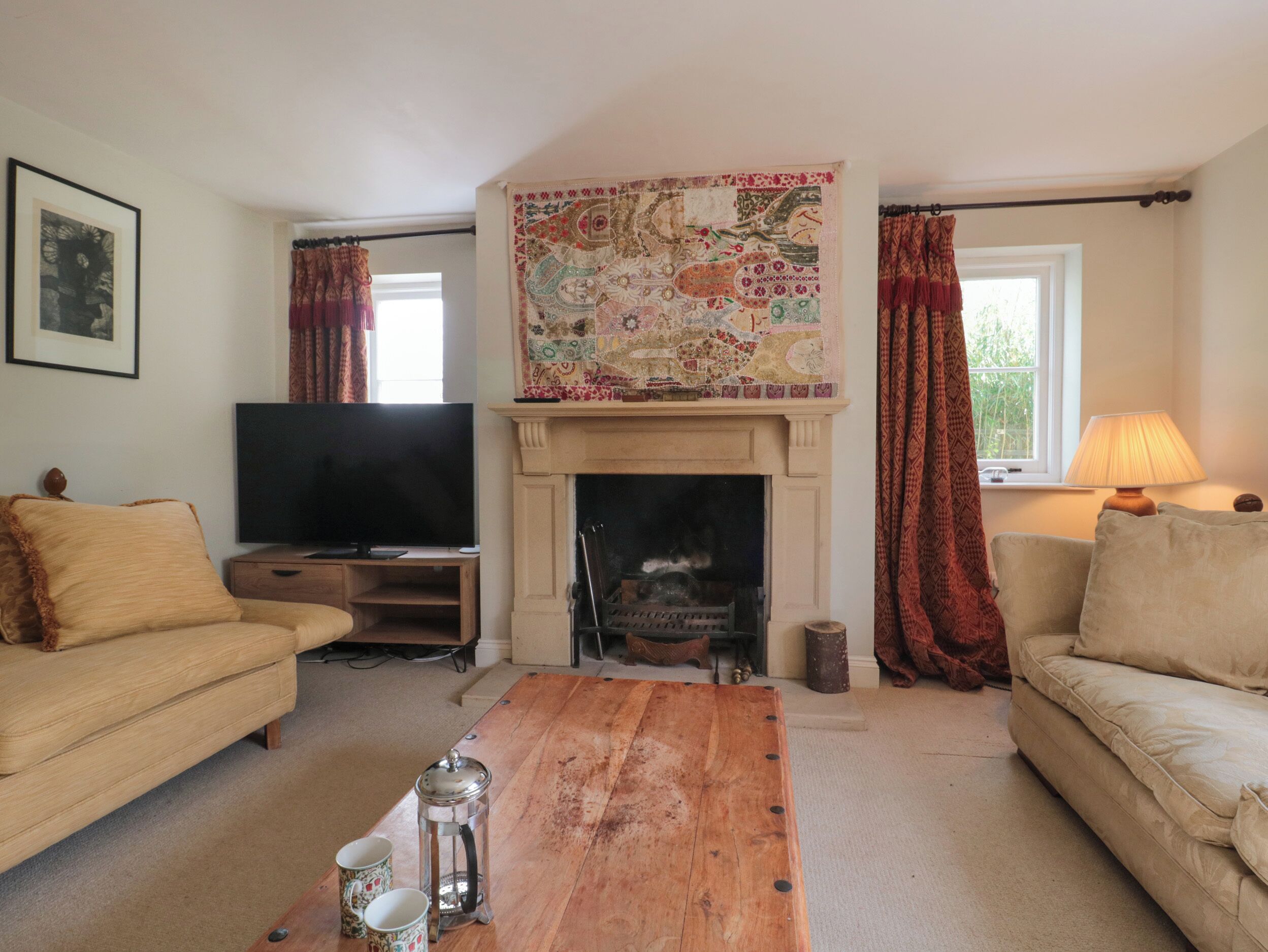 A living room with a fireplace, a television, and a coffee table.
