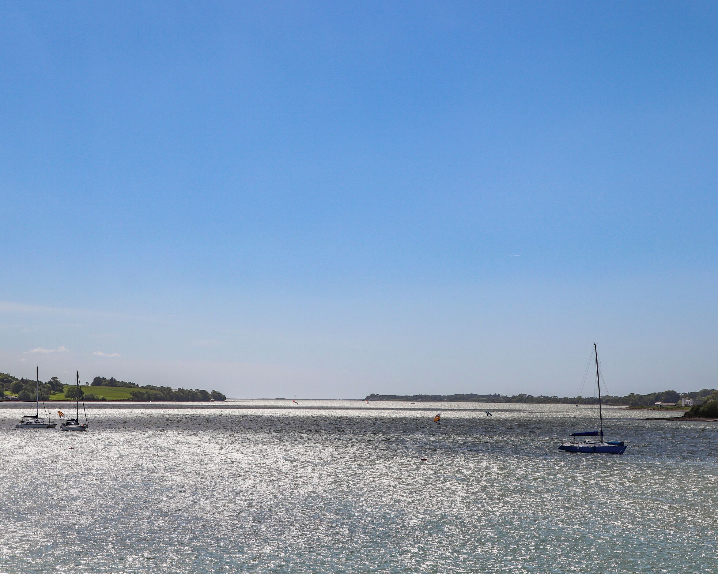Een rustig wateroppervlak met boten en een heldere lucht.