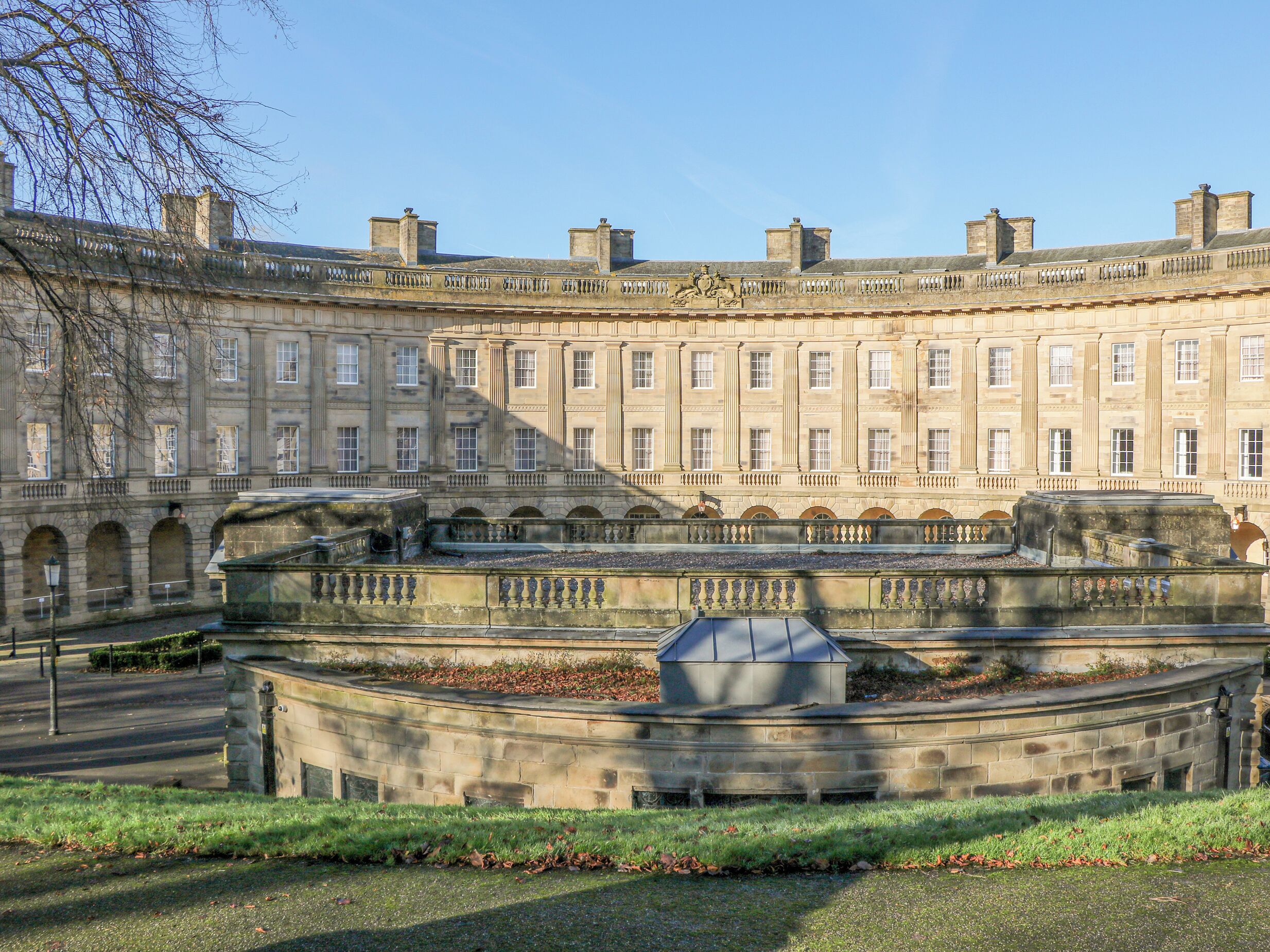 A historic building with a symmetrical facade, multiple windows, and a central courtyard with a fountain.