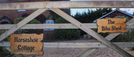 A wooden sign with "Horseshoe Cottage" and "The Bike Shed" labels.