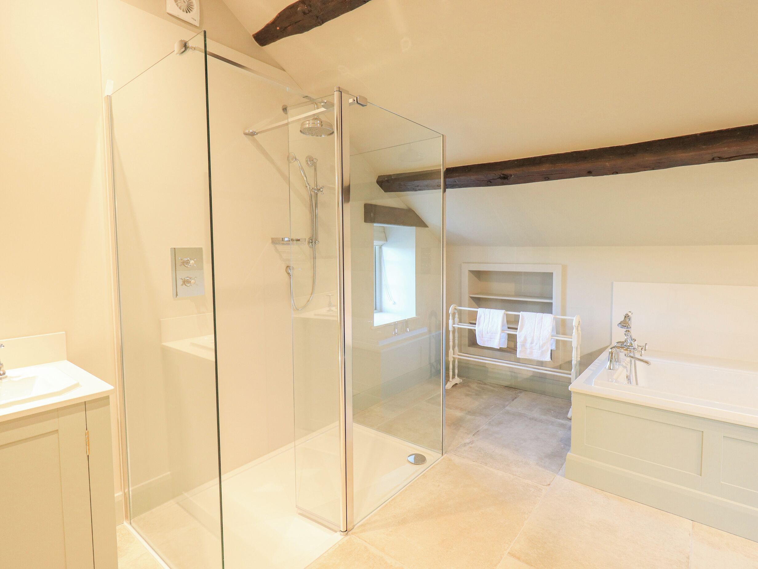 Un bagno moderno con doccia vetrata, mobile lavabo bianco e vasca da bagno.