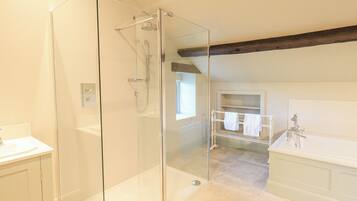Un bagno moderno con doccia vetrata, mobile lavabo bianco e vasca da bagno.