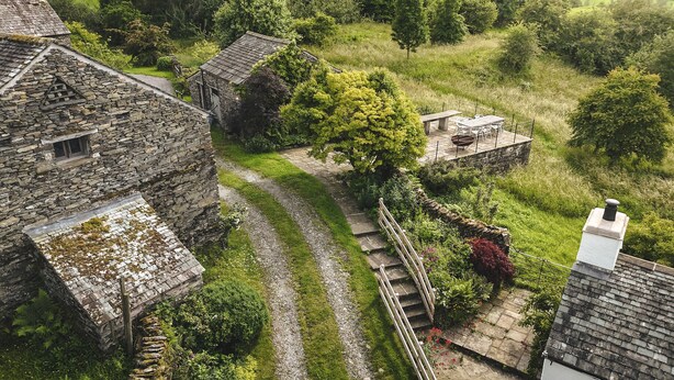Un bâtiment en pierre avec un escalier en pierre menant à un jardin.