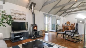 A cozy living room with a fireplace, a television, and a dining area with a table and chairs.