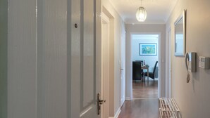 A hallway with a door labeled '30', a ceiling light fixture, a framed picture on the wall, and a telephone. - The Chase - 30 Ayr Avenue (Catterick Garrison)