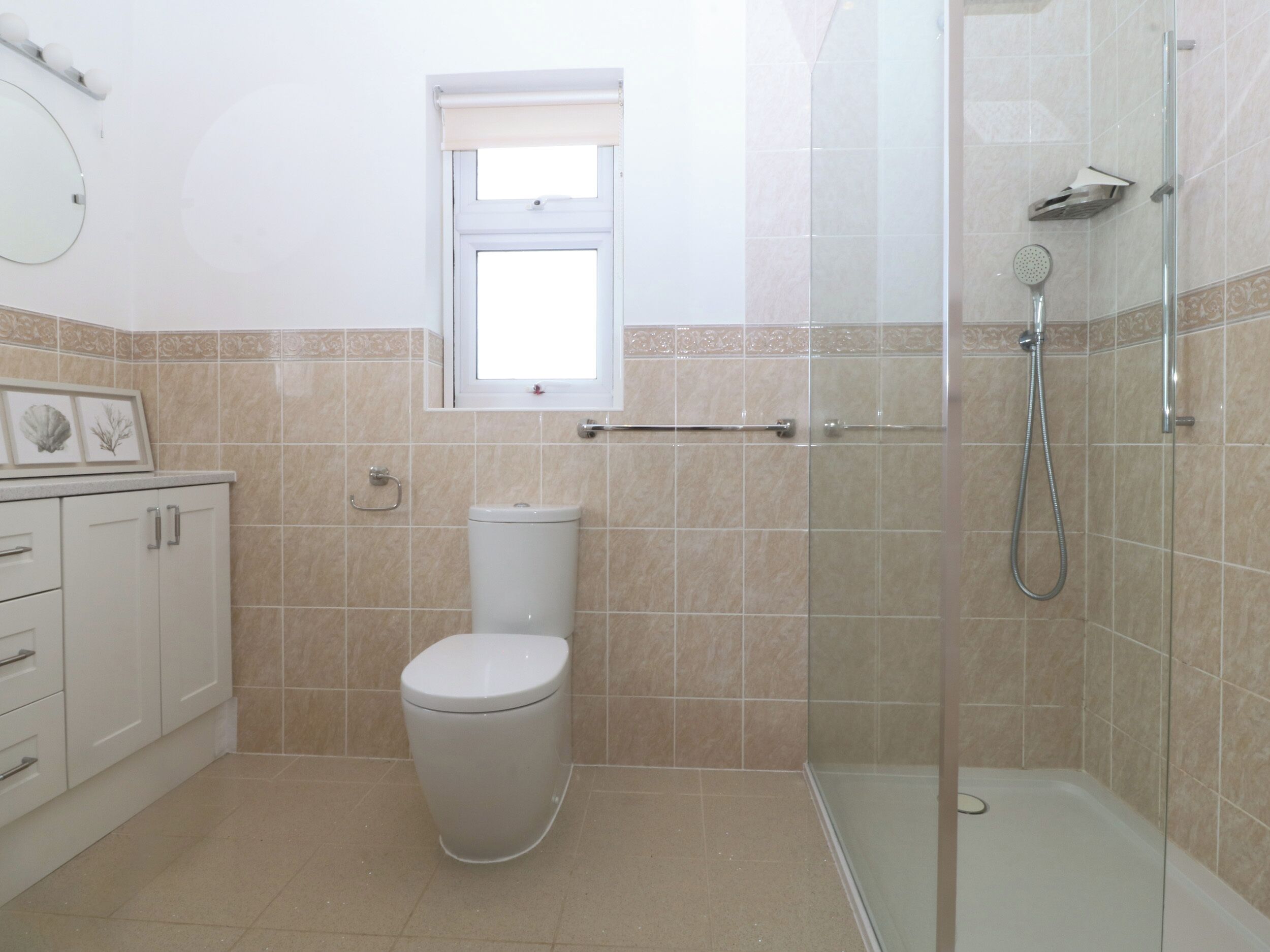 A bathroom with a toilet, a shower, and a window.