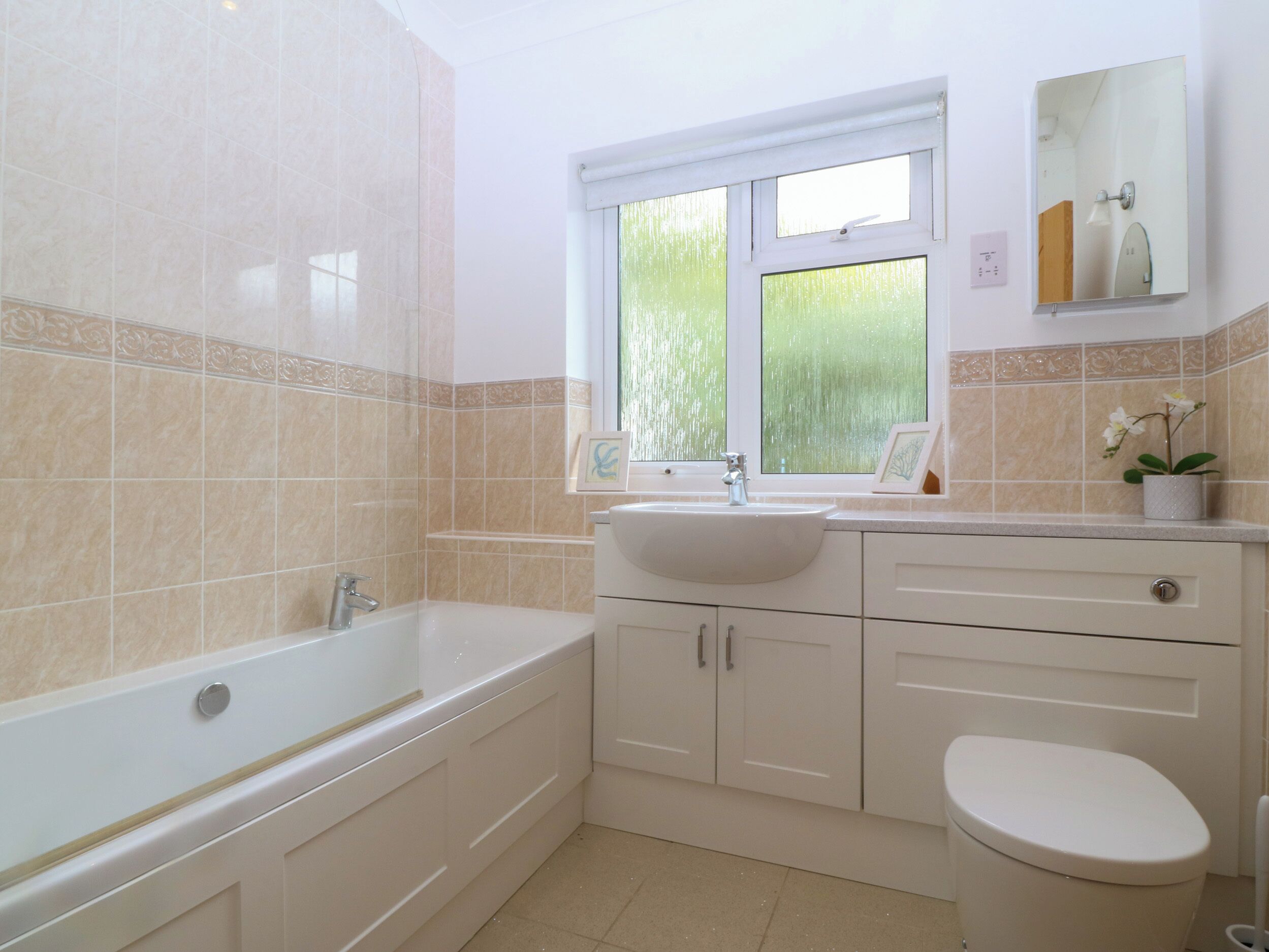A modern bathroom with a bathtub, sink, and toilet.