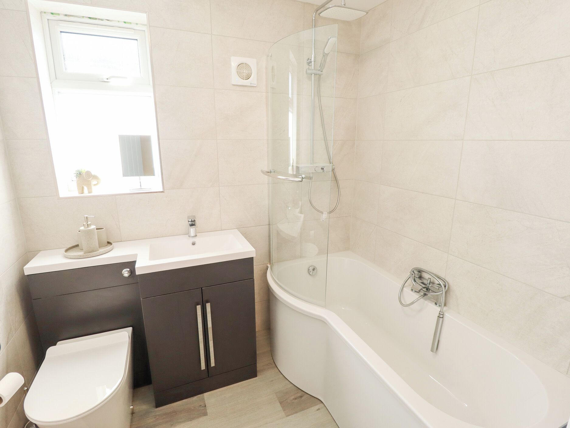 Un bagno moderno con toilette, lavandino, mobile lavabo e cabina doccia.