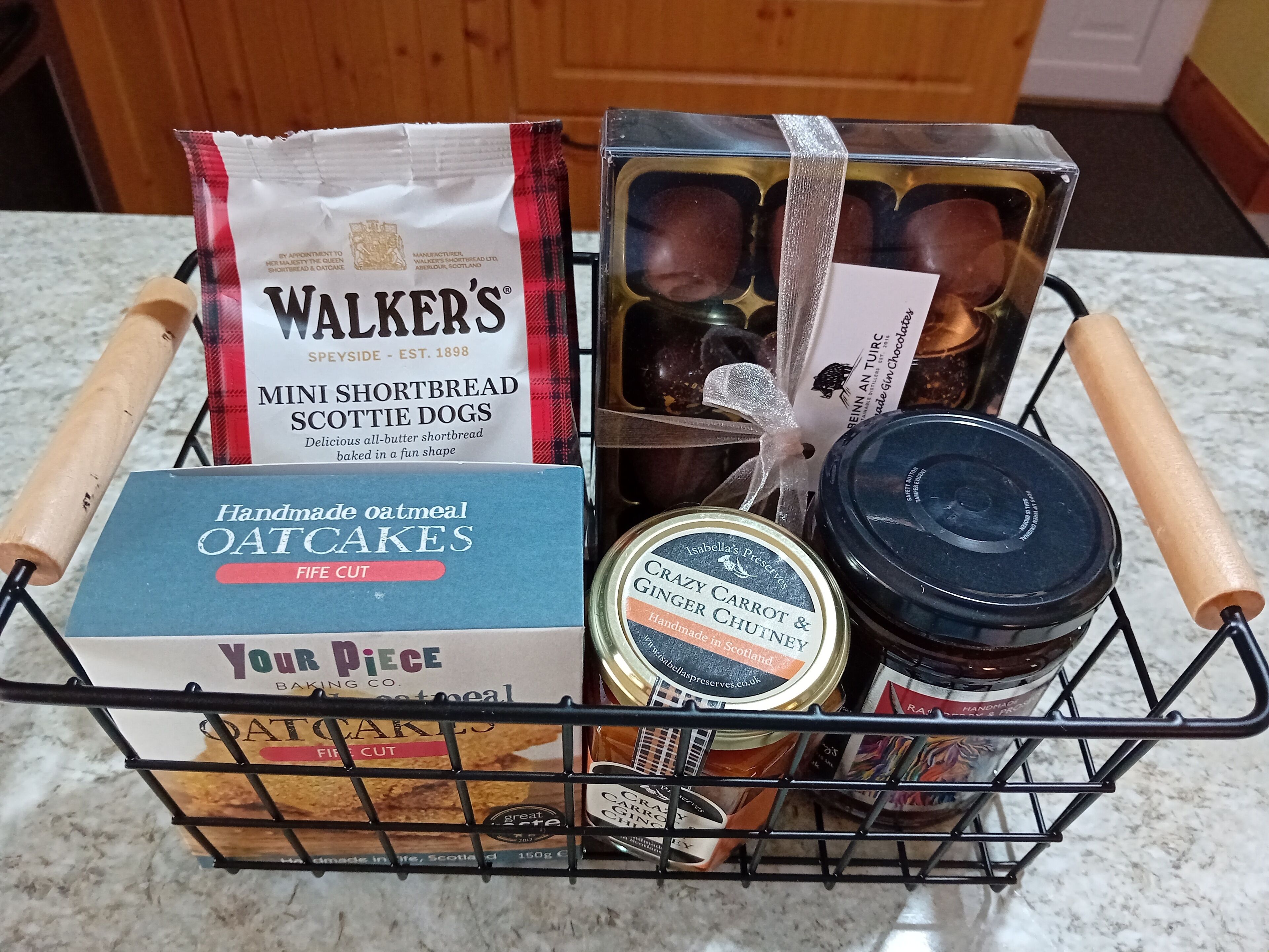 En kurv med Walker's Mini Shortbread Scotch Dogs, havrekiks og en dåse med karry-gulerodschutney.