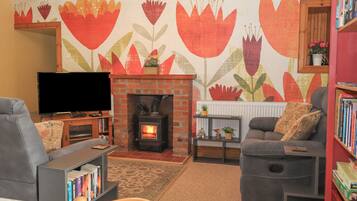 A living room with a fireplace, a television, and a bookshelf.