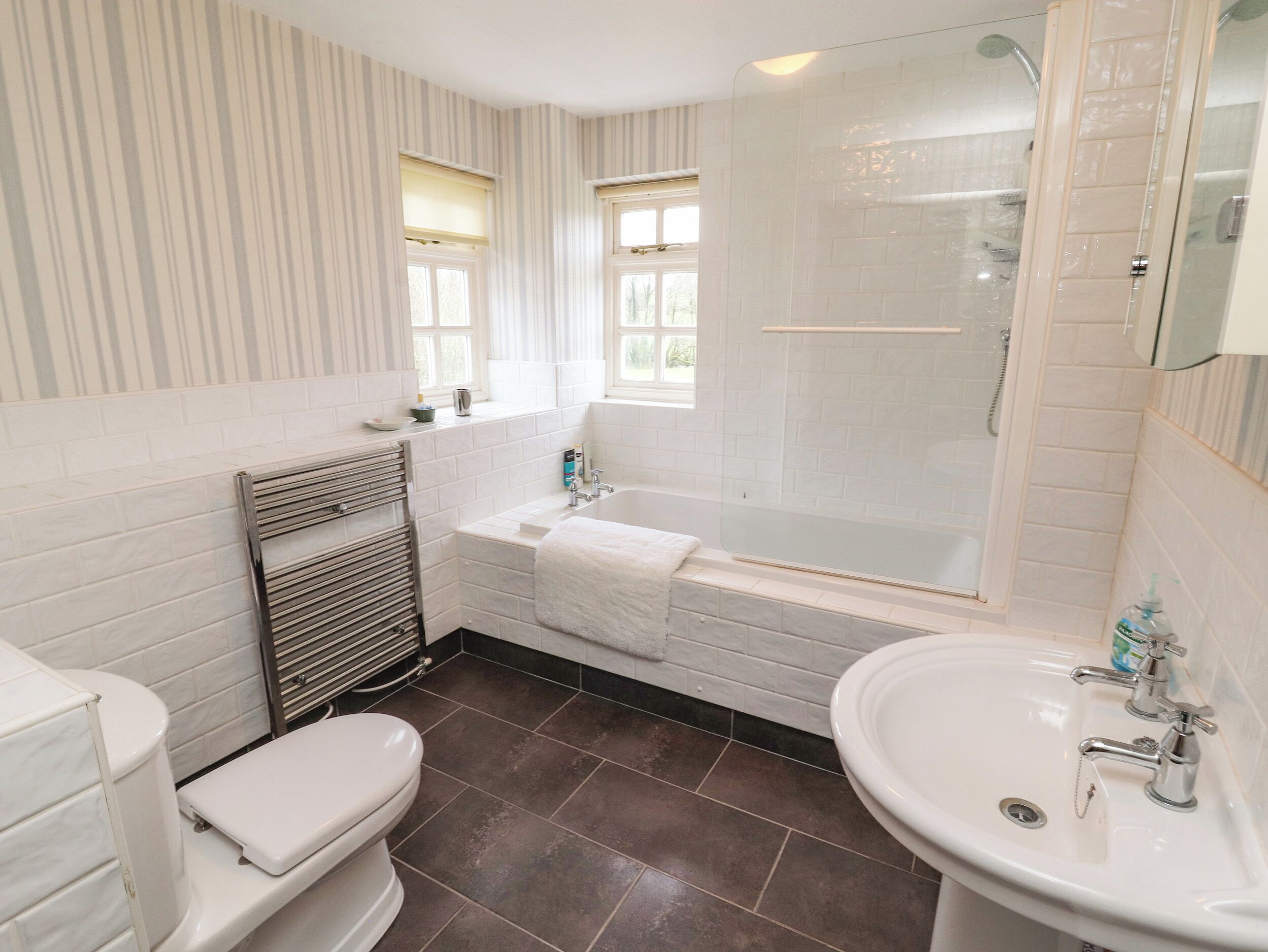 A bathroom with a bathtub, toilet, and sink.