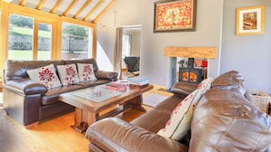 Una sala de estar acogedora con sofás de cuero, una mesa de centro de madera y una chimenea.